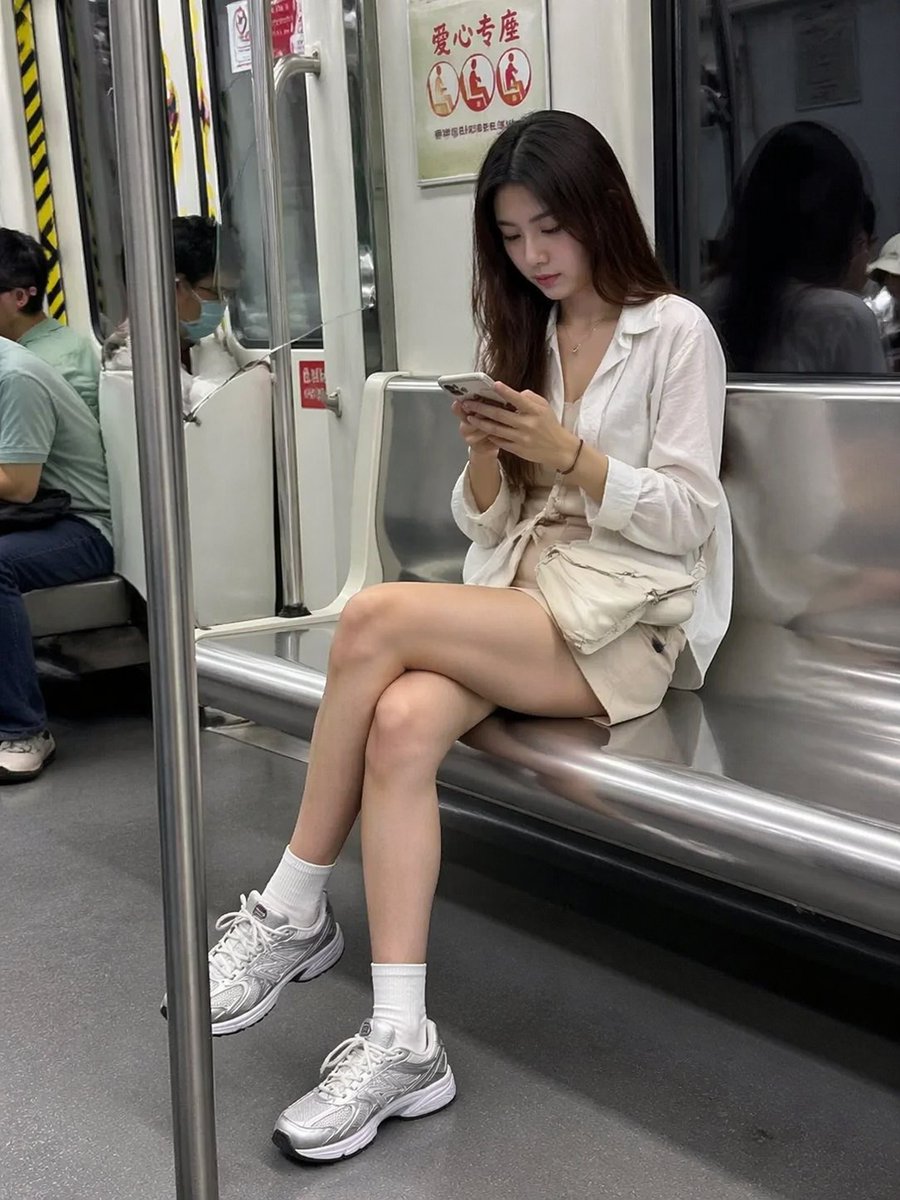 Candid Subway Photography Style Qwen Image prompt example: A realistic prompt for generating a candid-style photo of a woman on a subway looking at her phone.