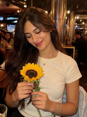Woman with Sunflower in Warm Restaurant Setting AI image template preview