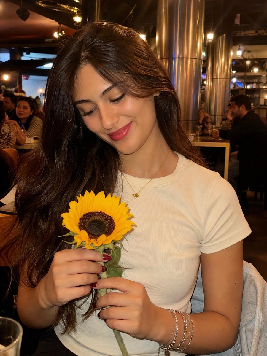 Woman with Sunflower in Warm Restaurant Setting