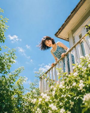 Low Angle Balcony Peeking Portrait — Close-up shot from low angle, young woman's face peeking over {argument name="balcony color" default="white"} balcony raili