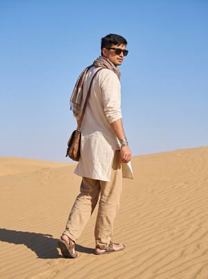 Sahara Desert Cinematic Portrait Prompt — A weathered {argument name="subject description" default="late-20s man"}. Clothing: Flowing cream-colored linen tunic,