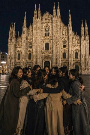 Milan Cathedral Night Group Hug — An intimate, candid late-night photograph of ten young Asian women, around 20 years old — {argument name="group composition" d