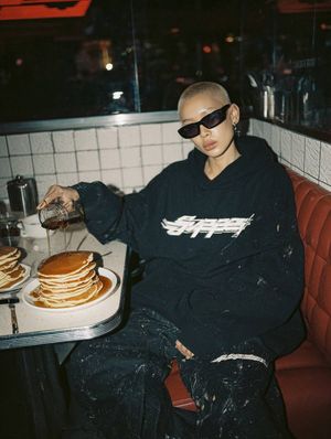 Kazakh Woman in Retro Diner — {argument name="subject" default="stylish young Kazakh woman"} sitting in a {argument name="setting" default="retro diner booth"},