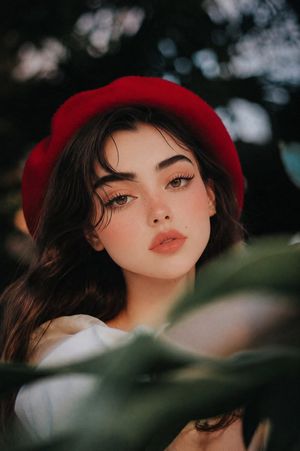 Dreamy Red Beret Garden Portrait — Create a photorealistic editorial portrait of a young woman with {argument name="hair color" default="dark brown"} long softl