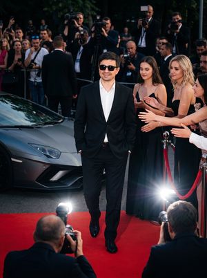 Celebrity Red Carpet Cinematic Portrait — Generate a hyper-realistic, cinematic 8k image of the uploaded man with his face fully preserved. he is wearing {argum