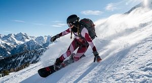 Action Snowboarder Mountain Shot — A dynamic action shot of a {argument name="subject" default="man snowboarder"} with a nice hairstyle wearing a modest, struct
