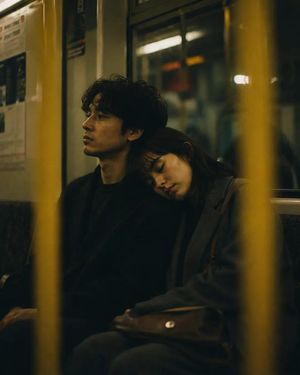 Cinematic Night Subway Couple Portrait — Cinematic candid photograph of a {argument name="young couple" default="young couple"} sitting together on the seat of 