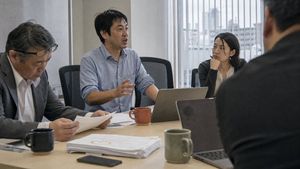 Realistic Japanese Office Meeting — Create a realistic documentary-style office meeting photograph in a modern Japanese conference room. Show exactly 4 people a