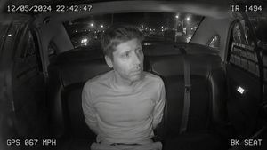 Infrared Police Back Seat Cam — Using the provided reference image as the identity reference, transform the person into a grainy black-and-white infrared police